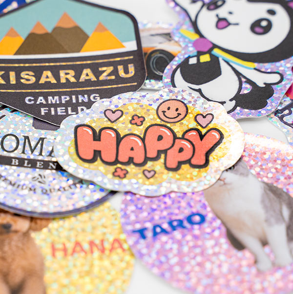 キャンプ場のロゴや「HAPPY」のロゴ、猫の写真を印刷した、ドット柄のアンダーホロステッカー